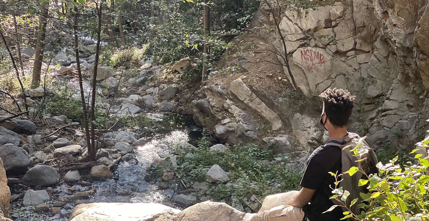 Raymond exploring a rocky creek on a hike